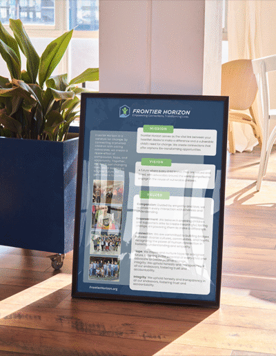 Framed Frontier Horizon poster displaying the organization’s mission, vision, and values next to a blue planter inside a sunlit room with wood flooring.