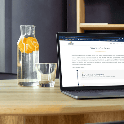 Laptop on modern desk showing a professional service website page with step-by-step client process.