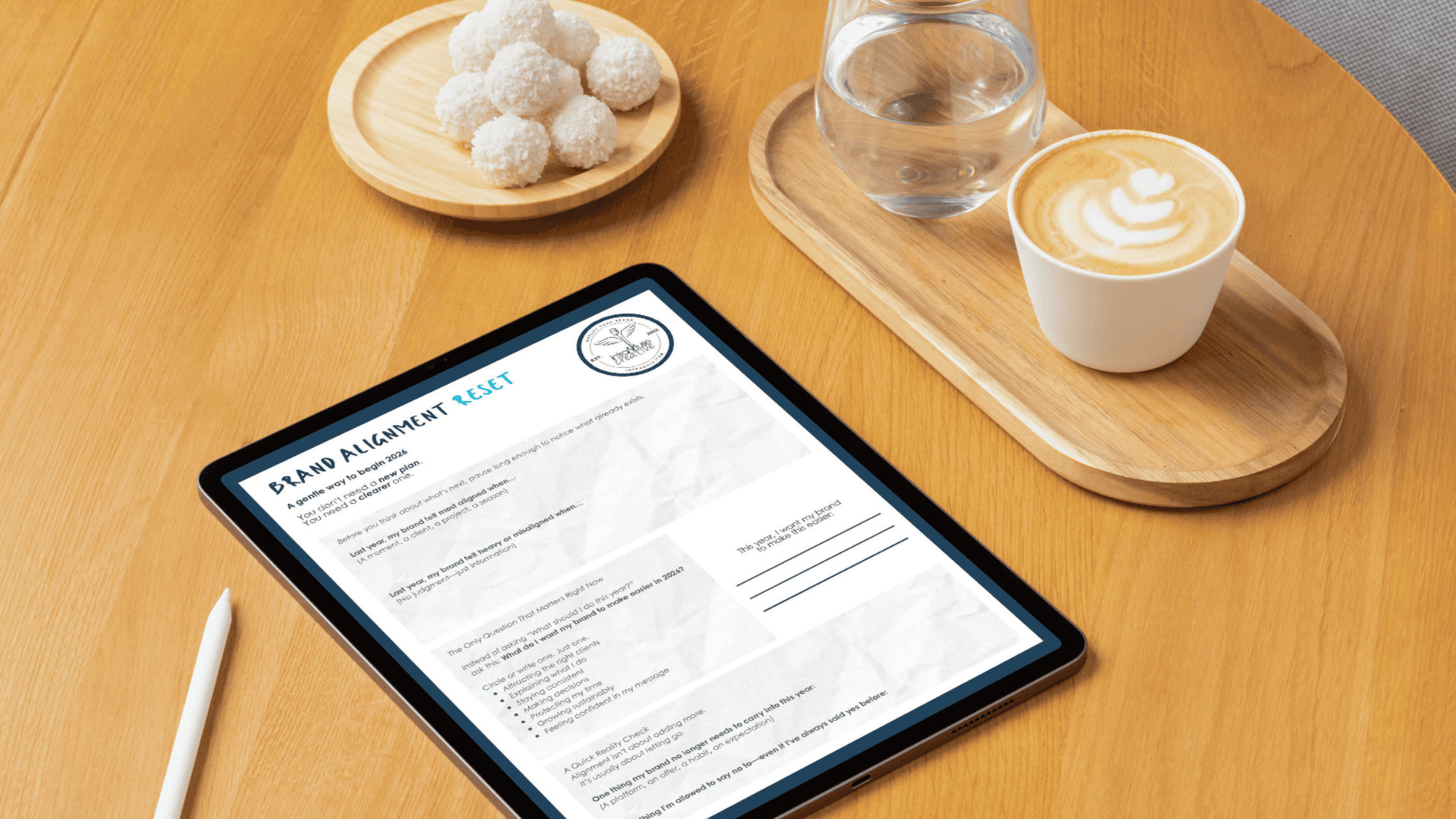A person completing the Brand Alignment Reset on an iPad Pro using the GoodNotes app, with an Apple Pencil, coffee, and a minimalist workspace setting.